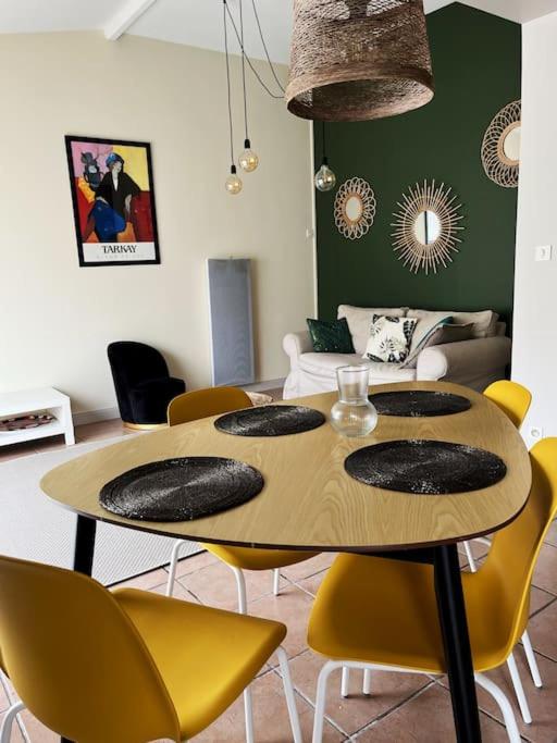 une salle à manger avec une table et des chaises jaunes dans l'établissement Maison cosy avec parking gratuit, à Jarnac