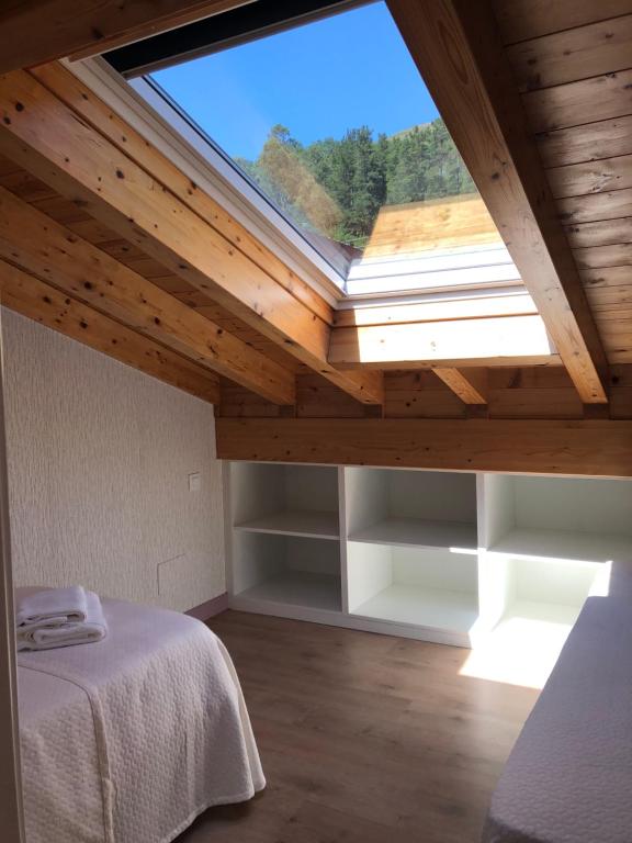 um quarto com uma grande janela num tecto de madeira em Casa particular en Renedo de Cabuérniga em Renedo