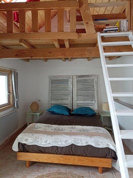 une chambre avec un lit superposé avec une échelle dans l'établissement le Caraquet, à Boursin