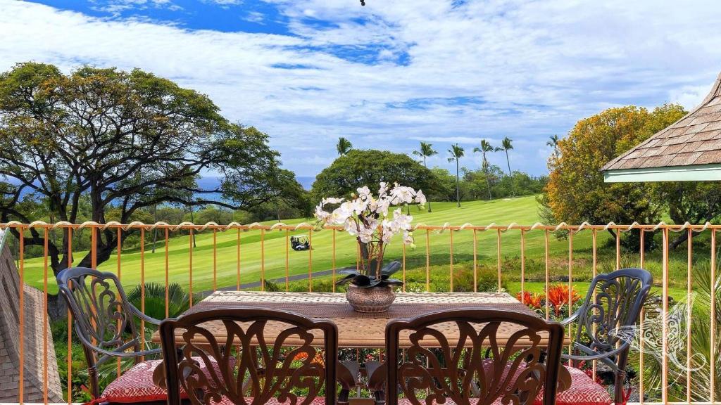 a table with a vase of flowers on top of it at Hale Hāhālua - Hale Hahalua - Serenity and Ocean Views in Kona now with AC in Kailua-Kona