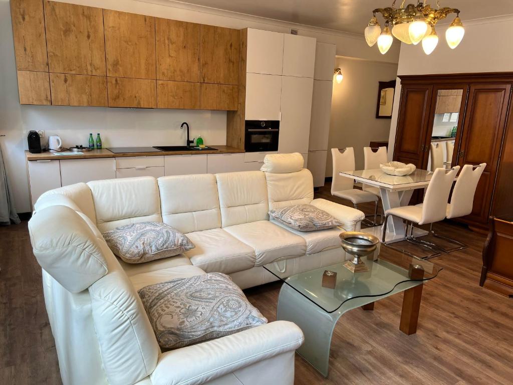 a living room with a white couch and a table at Apartamenty pod Katedrą in Bielsko-Biała