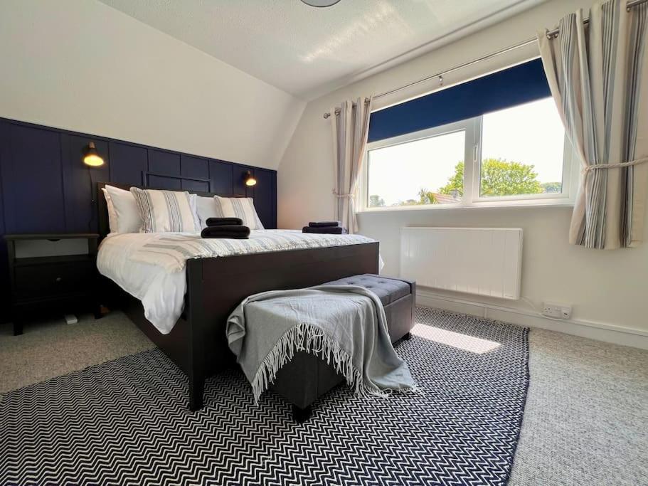 a bedroom with a large bed and a large window at Little Hill - A Hidden Gem in Salcombe