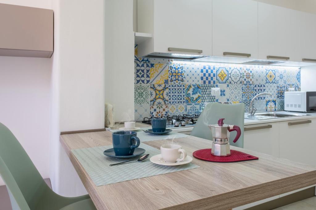 una cocina con mesa de madera y set de té. en Majolica Home, en San Gregorio di Catania