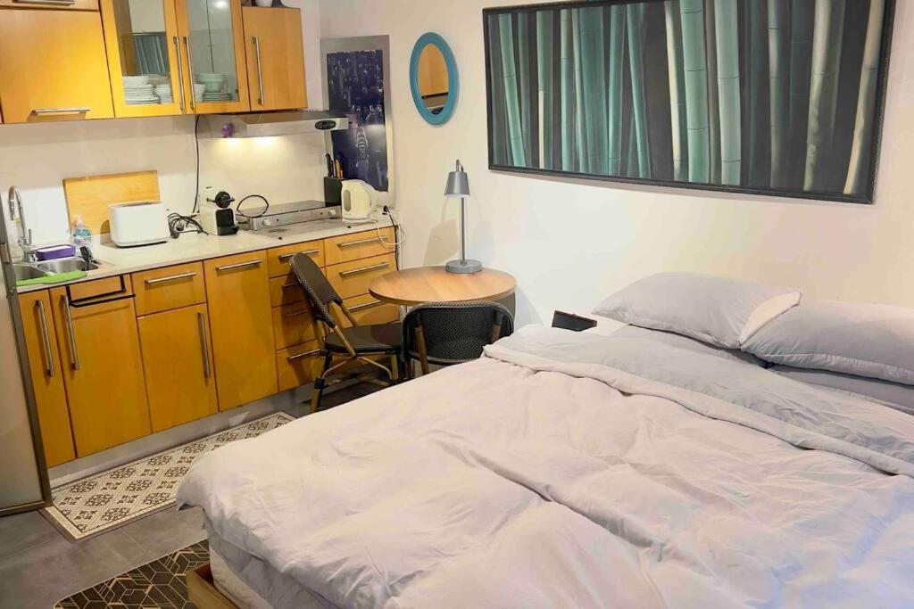 a bedroom with a bed and a small kitchen at Studio in the best place of town! in Tel Aviv