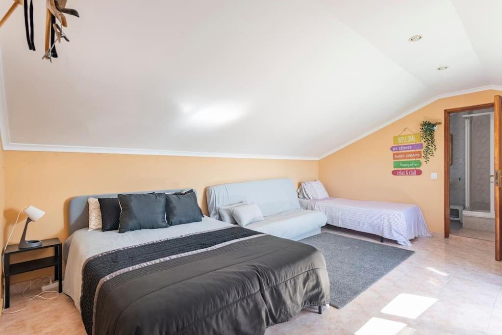 ein Schlafzimmer mit einem großen Bett und einem Sofa in der Unterkunft Casa de Vasco in Amora