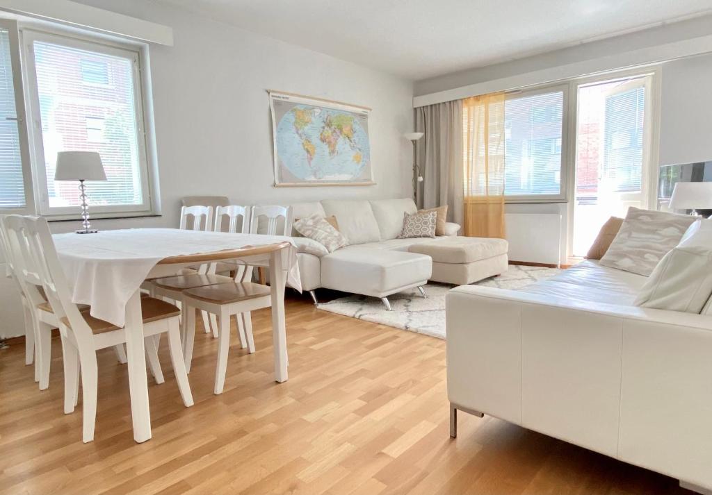 a white living room with a table and a couch at Joensuu keskustaneliö in Joensuu