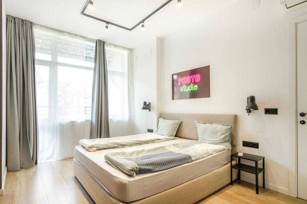 a bedroom with a bed with a sign on the wall at Viral 2 BR Photo Studio Loft in Sofia