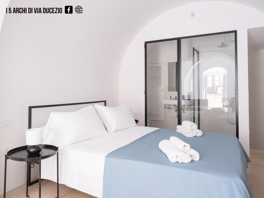 una camera da letto con un letto e due asciugamani di I 5 Archi di Via Ducezio a Noto