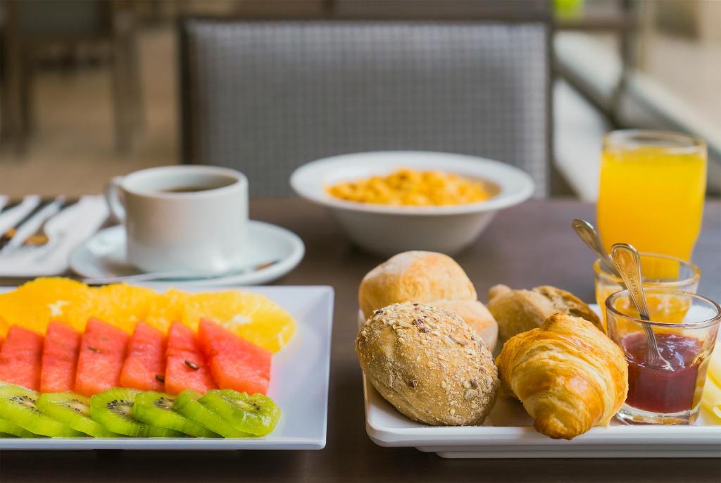 a table with two plates of food with fruit and bread at HF Tuela Porto in Porto