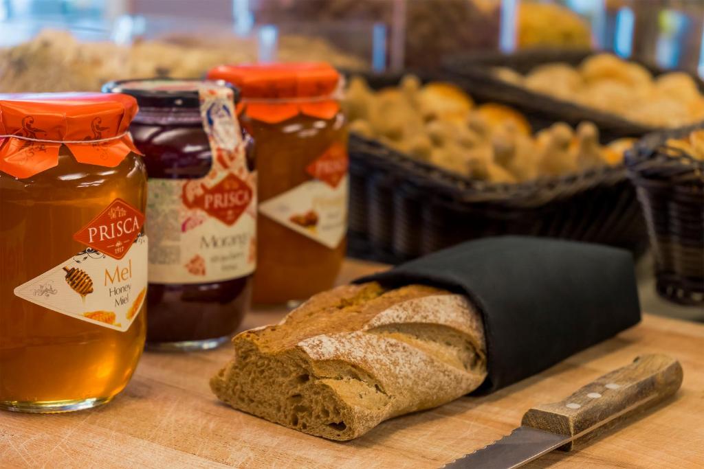 a table with a loaf of bread and jars of honey at HF Tuela Porto in Porto