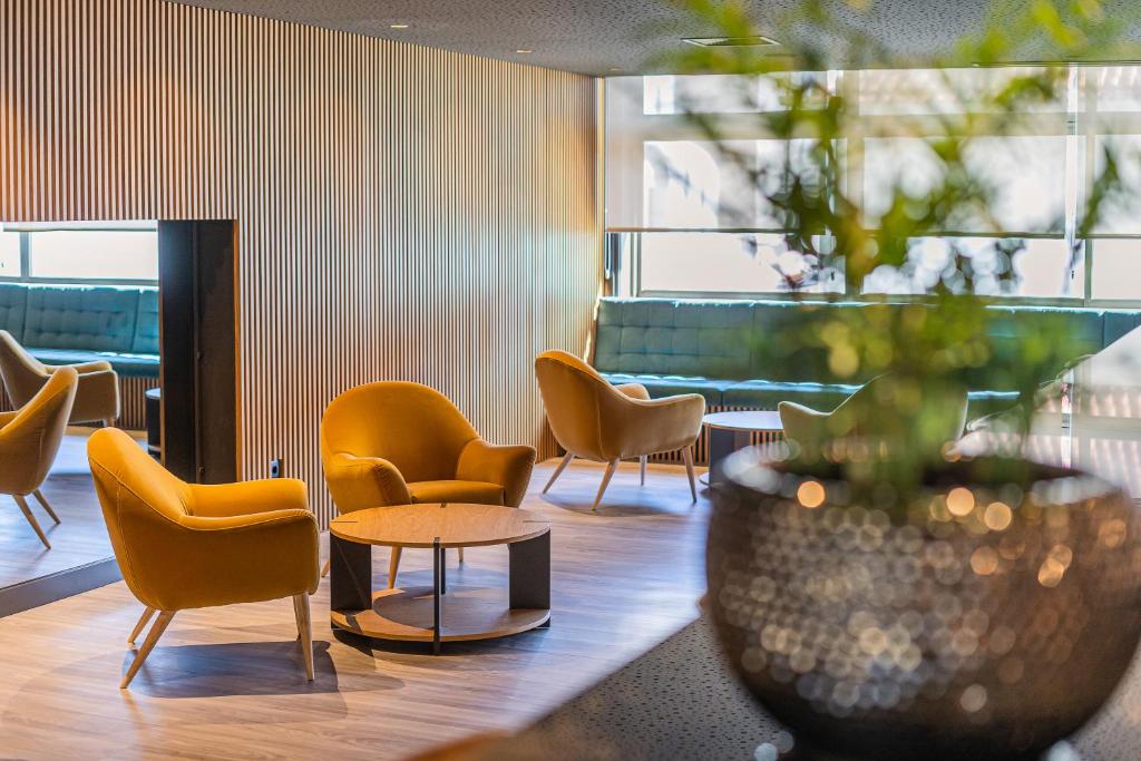 a waiting room with chairs and a table and a vase at HF Tuela Porto in Porto