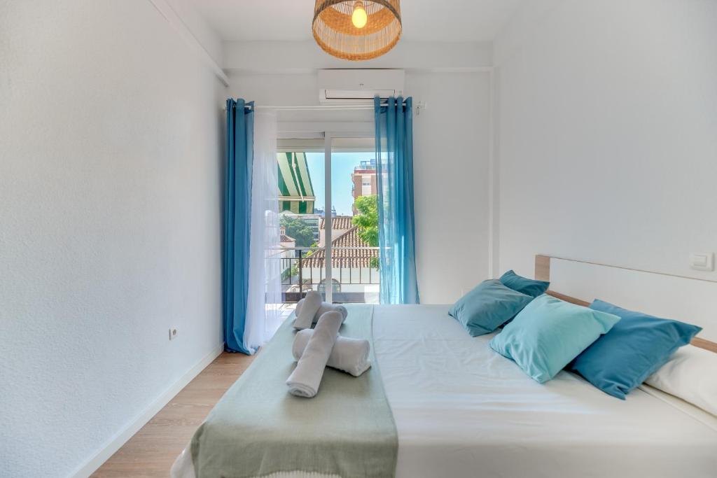 a bedroom with a large white bed with blue pillows at LXR Vistahermossa 3BDR. Apt Next to sea in Fuengirola