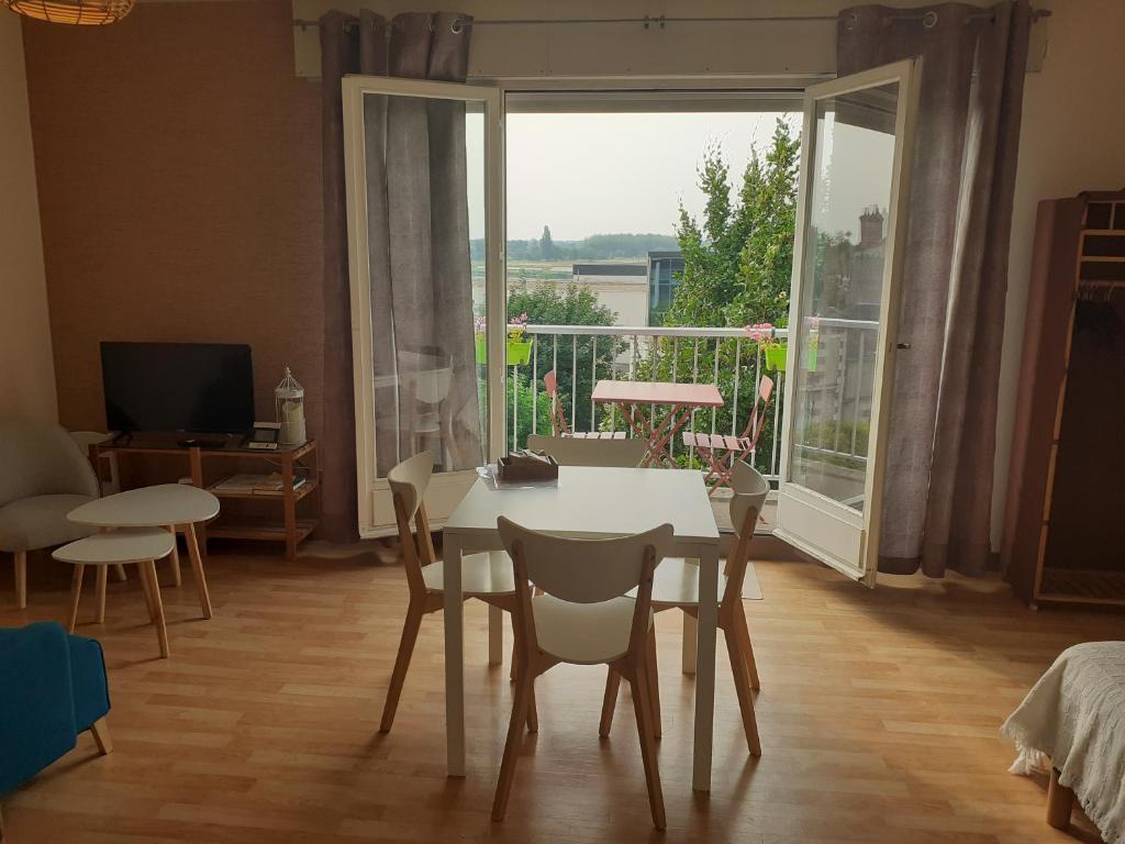 une salle à manger avec une table et des chaises et une grande fenêtre dans l'établissement L'échappée blésoise, à Blois