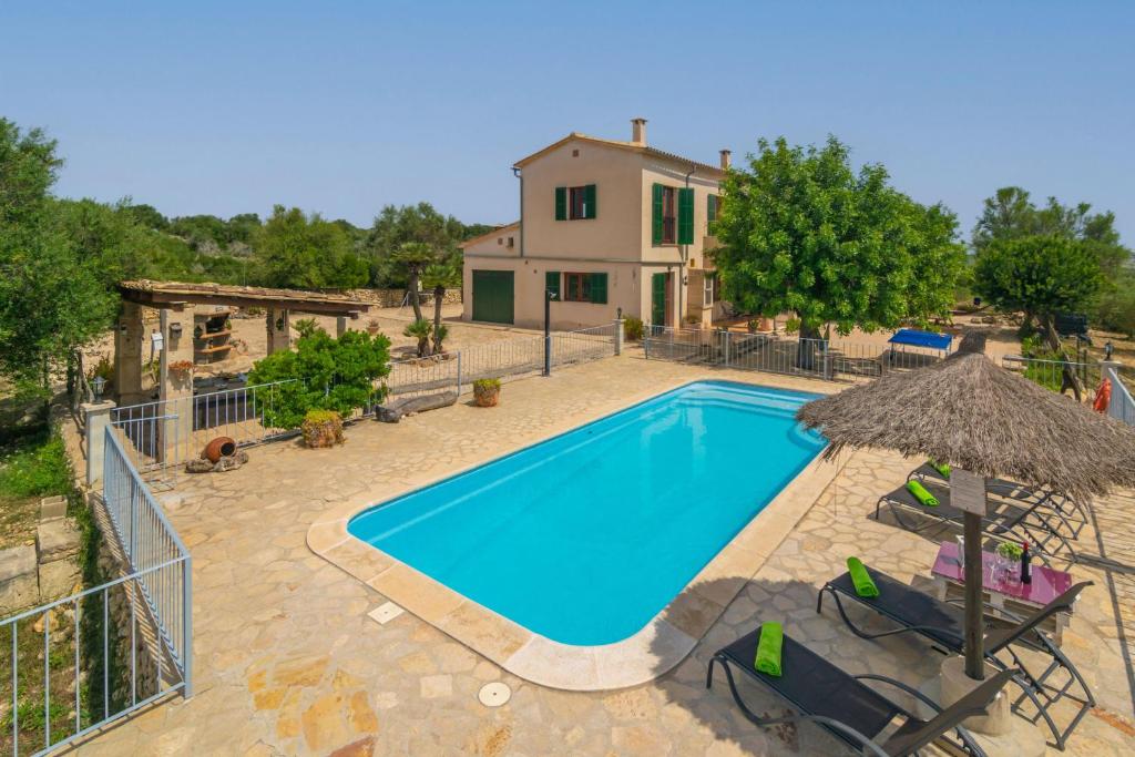 eine Villa mit einem Pool vor einem Haus in der Unterkunft Finca Son Puça in Petra