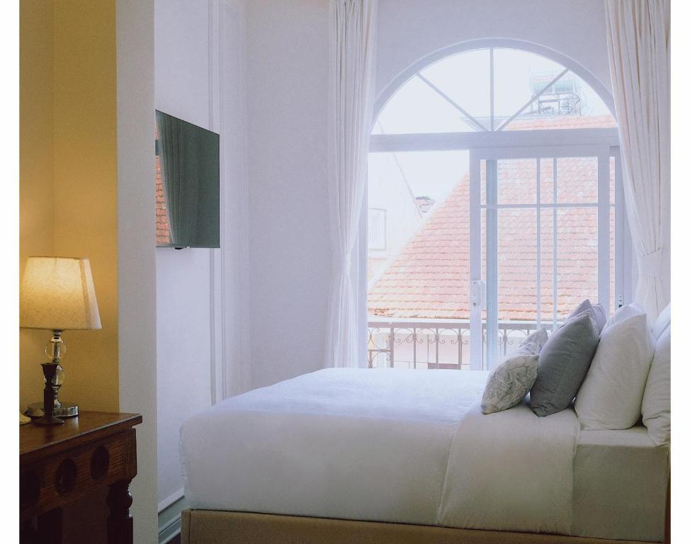 a bedroom with a bed and a large window at Le Macaron Boutique Hotel Đà Lạt - Dalat in Da Lat