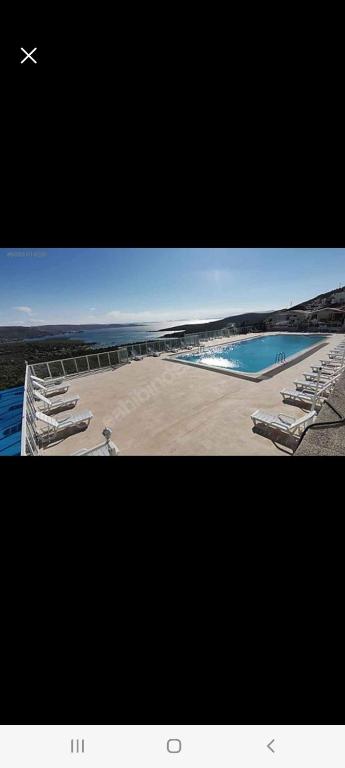 una foto de una piscina con tumbonas y un avión en Arko sitesi, en Karaburun