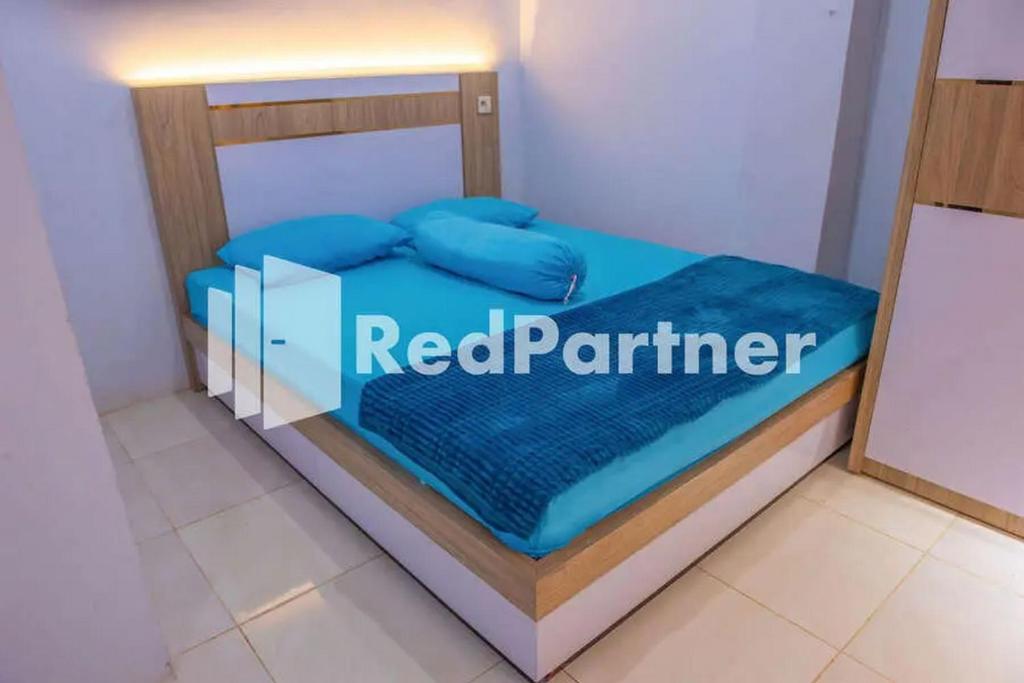 uma cama num quarto com um sinal de parceiro vermelho em Hotel Rai's Palopo Exclusive Mitra RedDoorz em Palopo