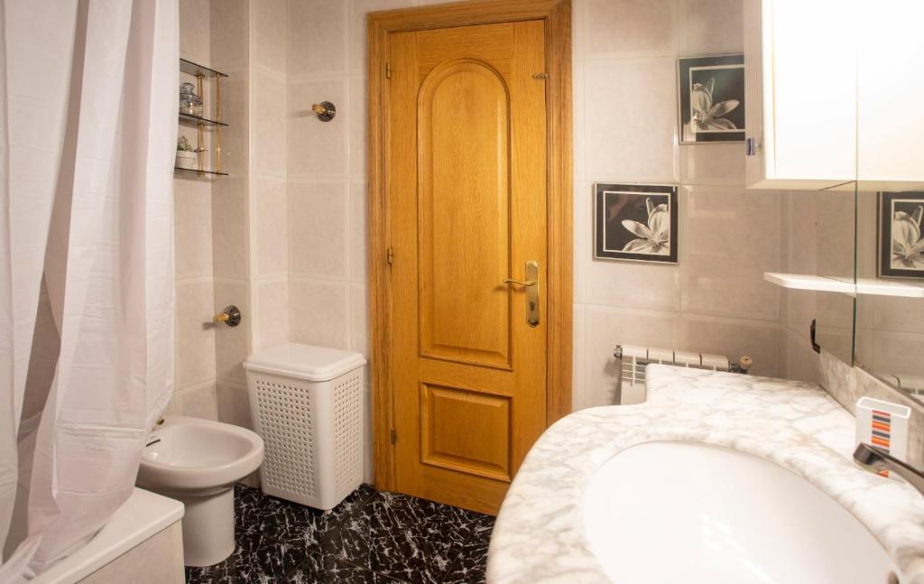 baño con aseo y puerta de madera en Apartamento Venecia en Unquera
