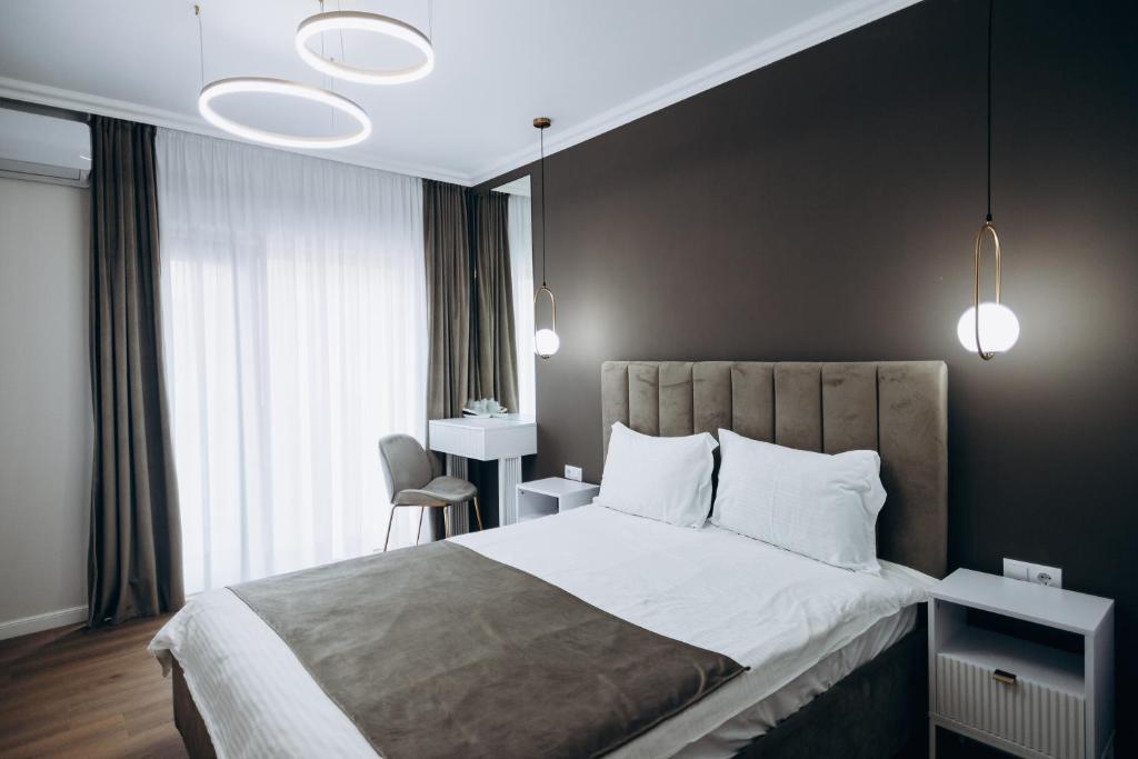 a bedroom with a large bed with white pillows at Pensiunea Brici Junior in Cluj-Napoca