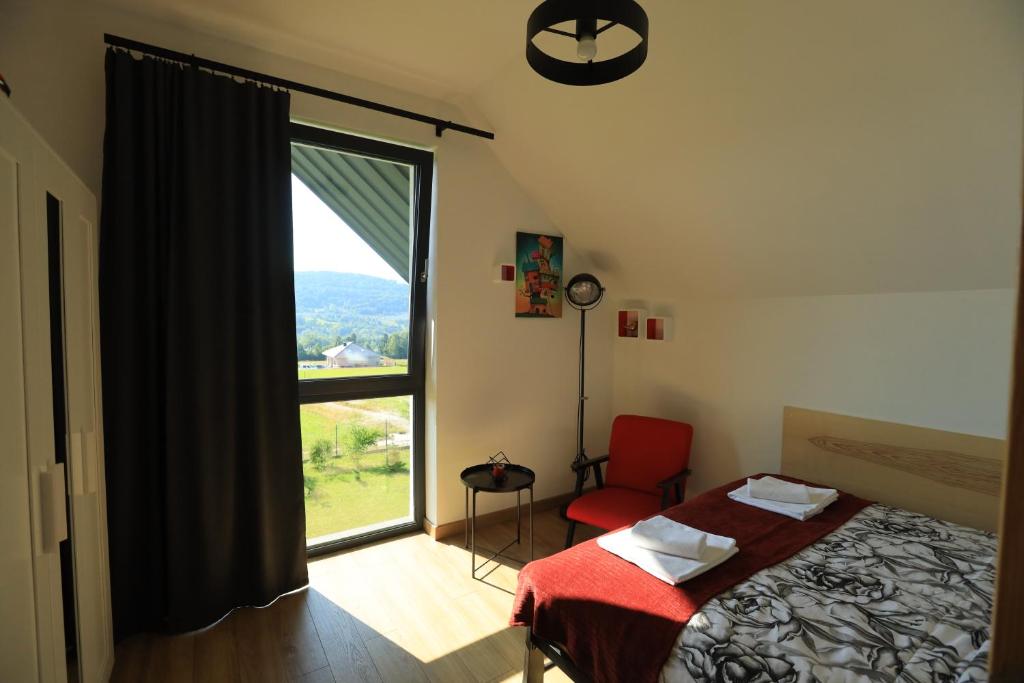 米卢夫卡Stodoła 55的一间卧室，里面有一张床和一扇大窗户。