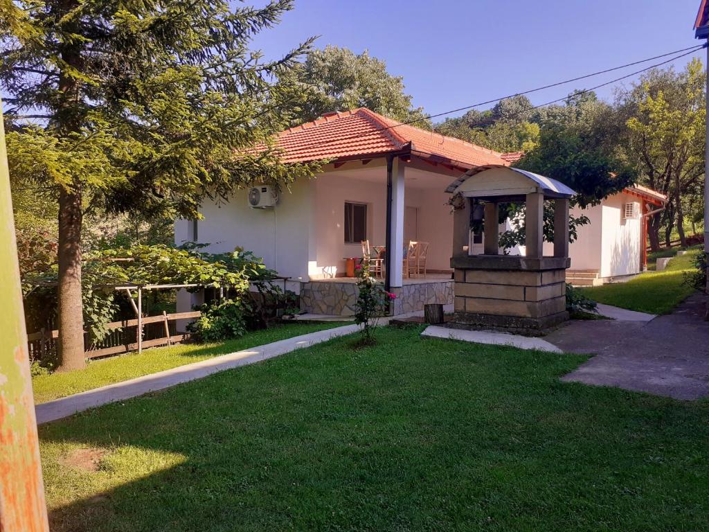 Gornja Toplica的住宿－Apartman Predah Banja Vrujci，一座带草地庭院的白色小房子