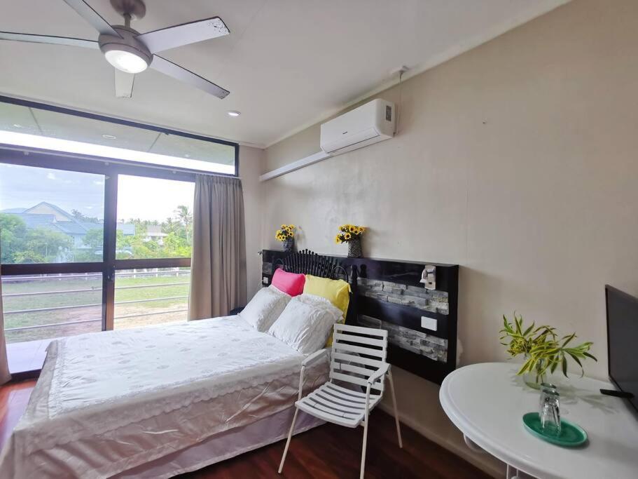 um quarto com uma cama, uma mesa e uma janela em Master Bedroom in Shared Cozy River View Pool Apartment em Nadi