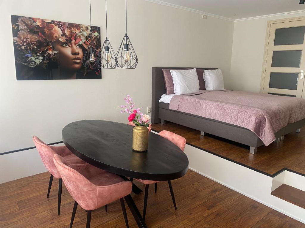 - une chambre avec une table, un lit, une table et des chaises dans l'établissement B&B Posthoorn, à Hoorn