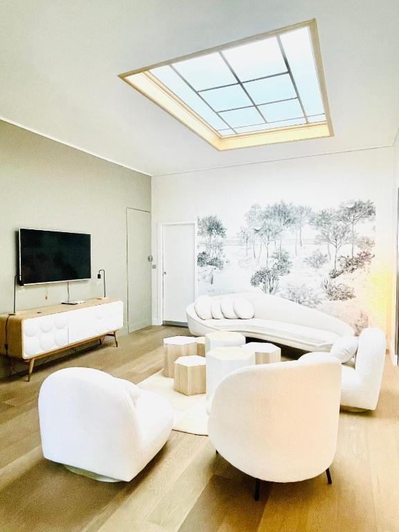 Il comprend un salon doté d'un mobilier blanc et d'une lucarne. dans l'établissement Hyper center Sauna air conditionner, à Reims