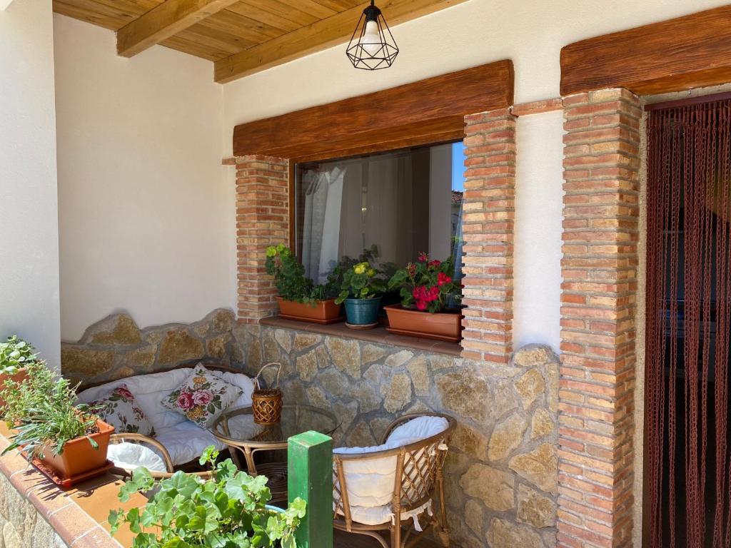 un patio con una pared de piedra y una ventana con plantas en Casa Sierra de Gata - Apartamento Rural, 