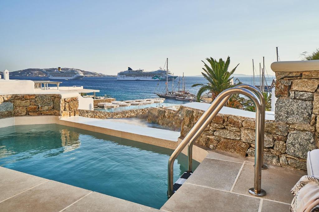 a swimming pool with a view of the water at Aqua Mykonos Suites - Adults Only in Tourlos