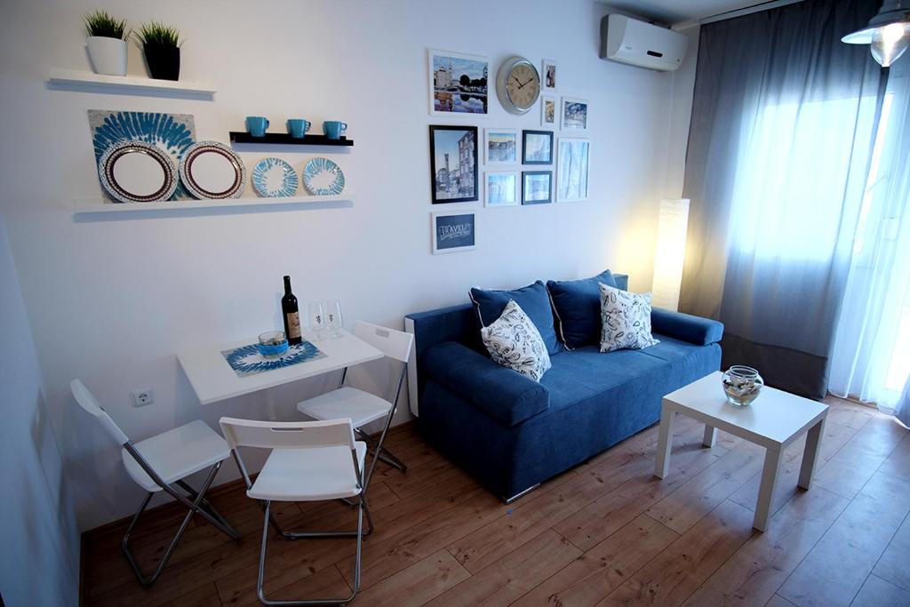 sala de estar con sofá azul y mesa en Studio Apartments Shanti, en Zadar