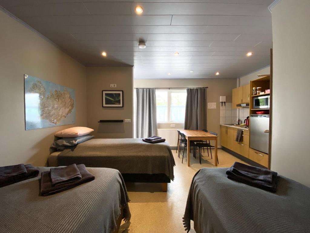 a hotel room with two beds and a kitchen at Studio Apartments in Seyðisfjörður