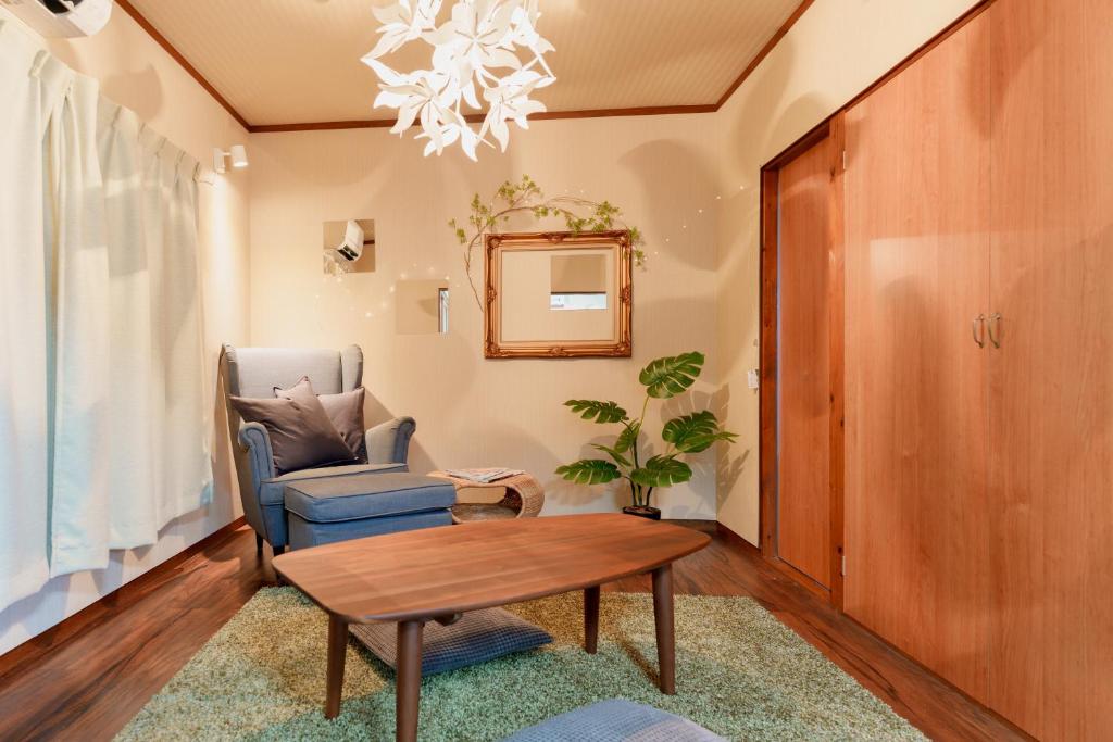 R-house 2nd 横浜 في Higashi-kanagawachō: غرفة معيشة مع كرسي وطاولة