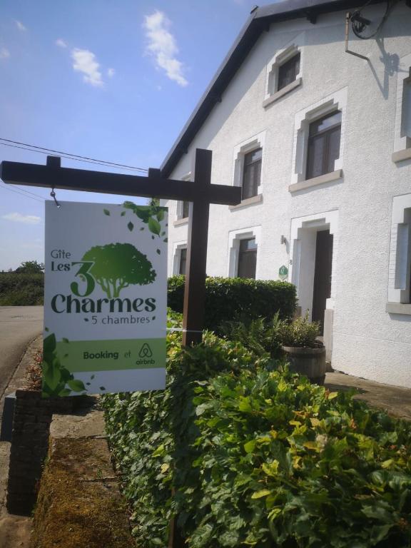 a sign in front of a white house at Gîte Les trois charmes in Gouvy