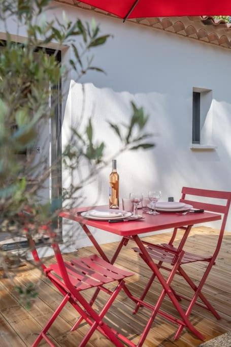 une table rouge et deux chaises sur la terrasse dans l'établissement Rêves de pampa Casa Bohème, à Lorgues