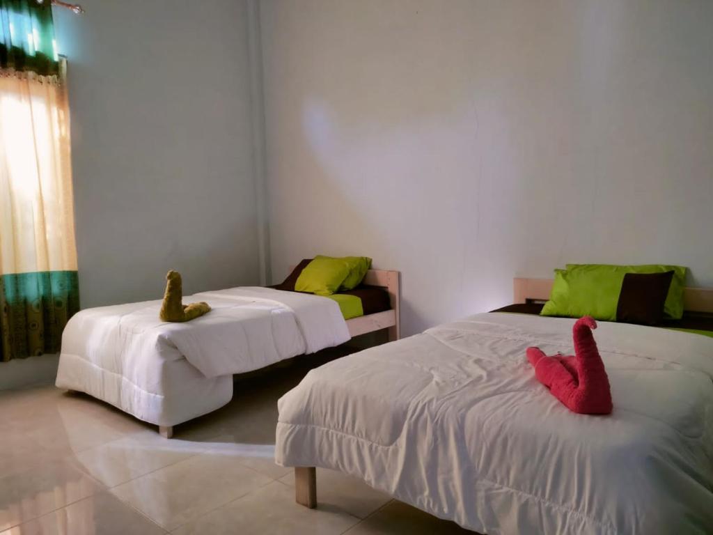 two beds with stuffed animals on them in a room at Tangkoko Safety Stop in Bitung