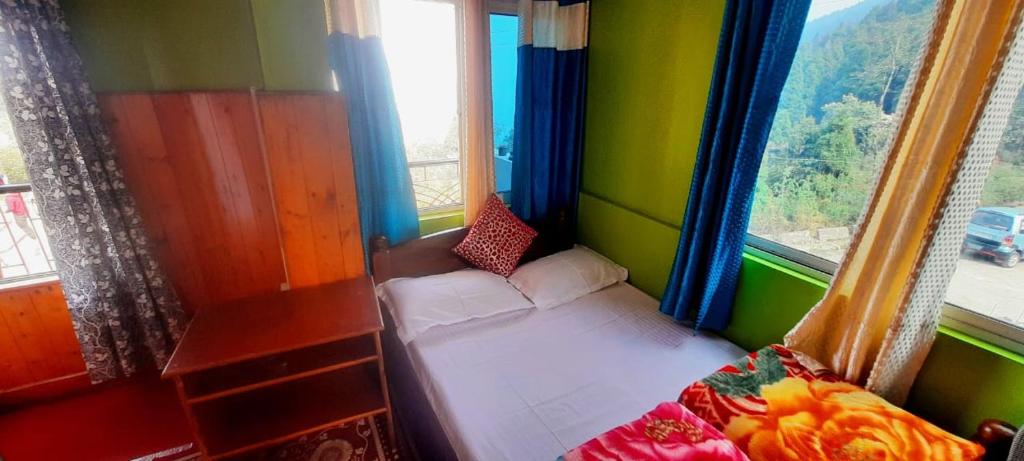 ein kleines Zimmer mit einem Bett und zwei Fenstern in der Unterkunft Bethel Homestay, Darjeeling in Darjeeling