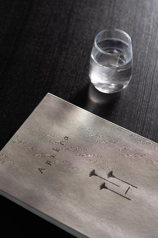 a piece of paper with a glass of water on a table at Apikia Santorini in Pirgos