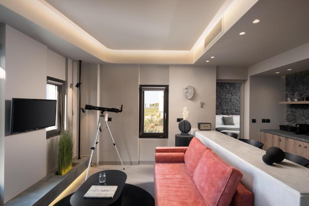 a living room with a couch and a television at Apikia Santorini in Pirgos