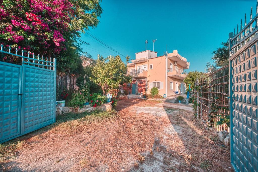 a driveway with a blue gate and a house at Mirror Beach Ksamil - Vila Zervo in Sarandë