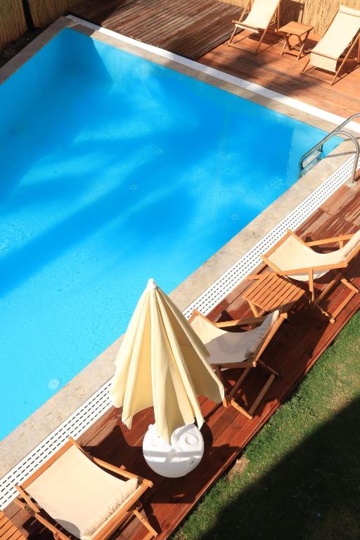 einen Pool mit Stühlen, einem Sonnenschirm und einem Pool in der Unterkunft La Sorella Butik Hotel in Ortaca
