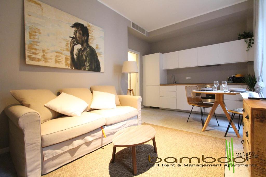 uma sala de estar com um sofá e uma cozinha em Bamboo Milano Umbria Apartment em Milão