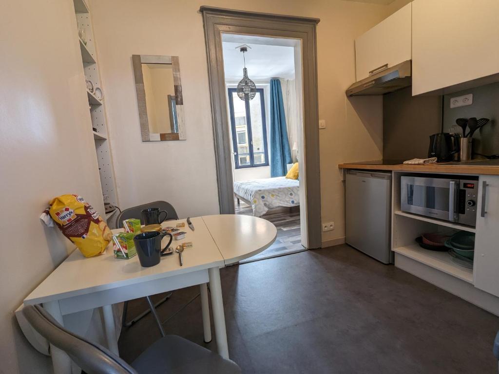 a small kitchen with a white table and a counter top at Appartement privé hyper centre de Boulogne S&#47;Mer in Boulogne-sur-Mer