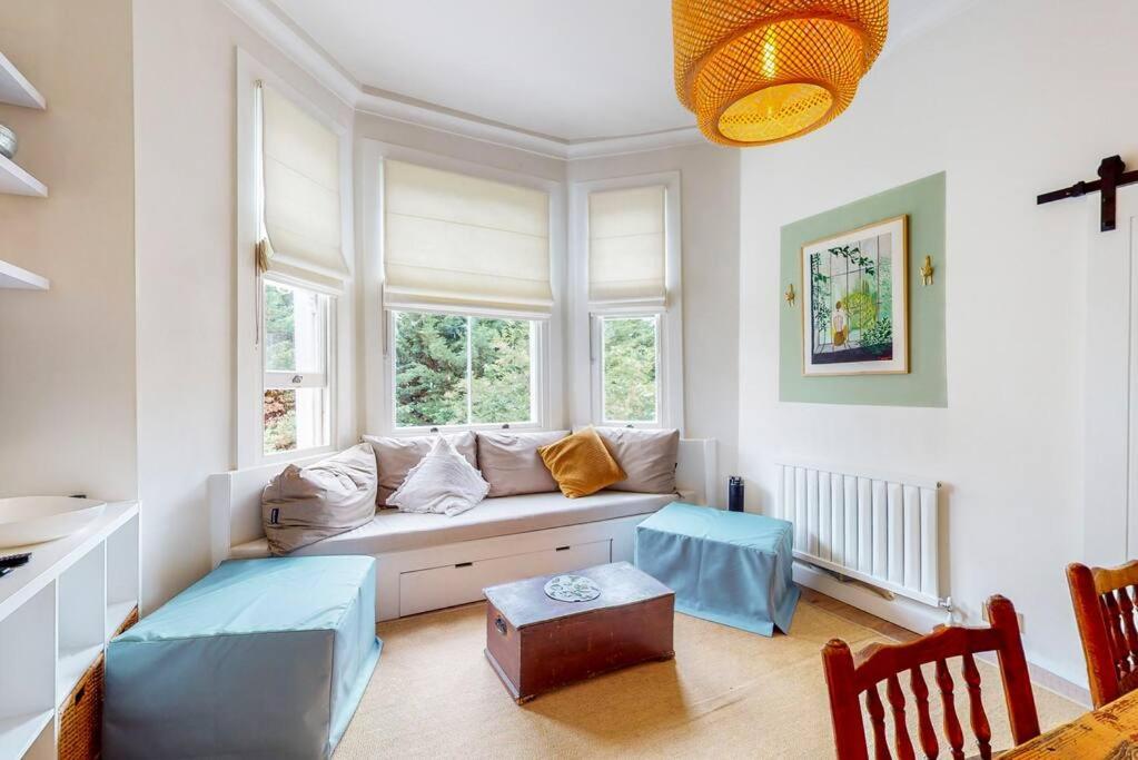 - un salon avec un canapé et 2 fenêtres dans l'établissement Beautiful 1 bedroom apartment in Shepards Bush, à Londres
