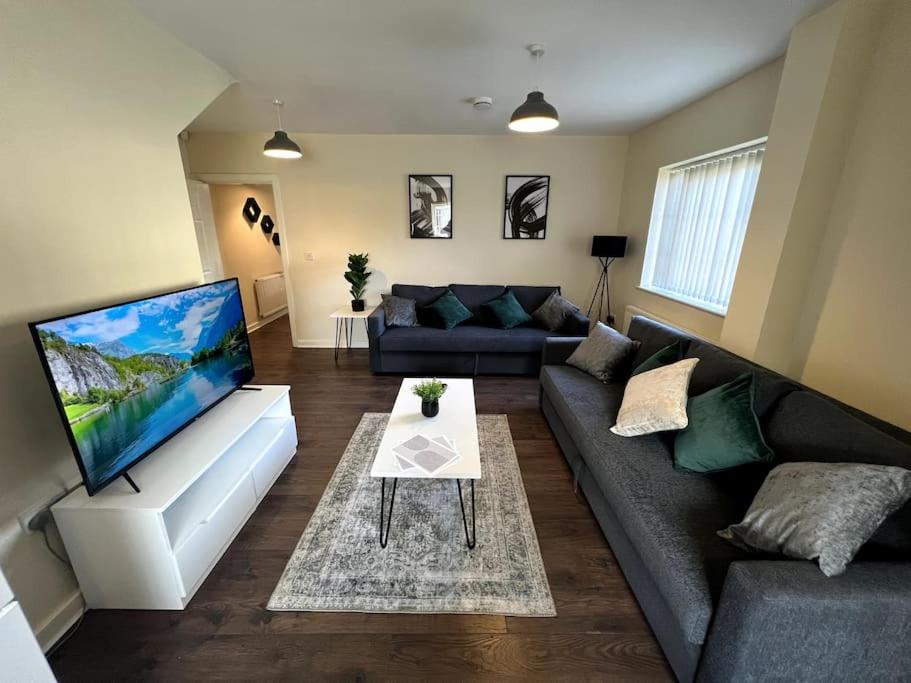 a living room with a couch and a tv at Wi-Fi, 2 bathroom, 2 bedroom, sleeps 4-8 in Birmingham