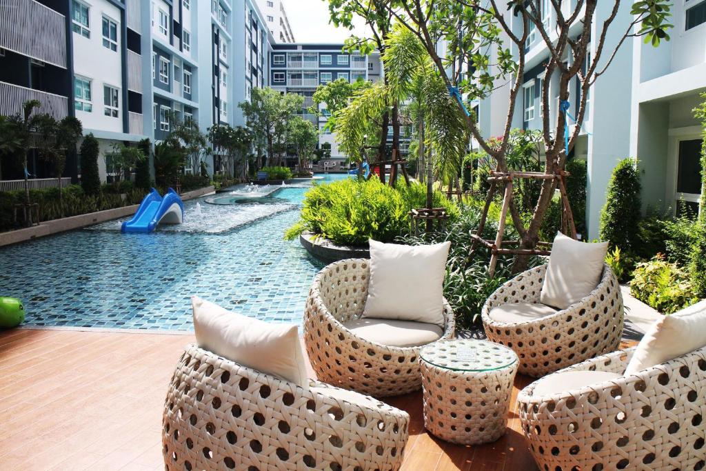 een binnenplaats met stoelen en een zwembad in een gebouw bij The Trust Pool & Garden Hua Hin in Hua Hin