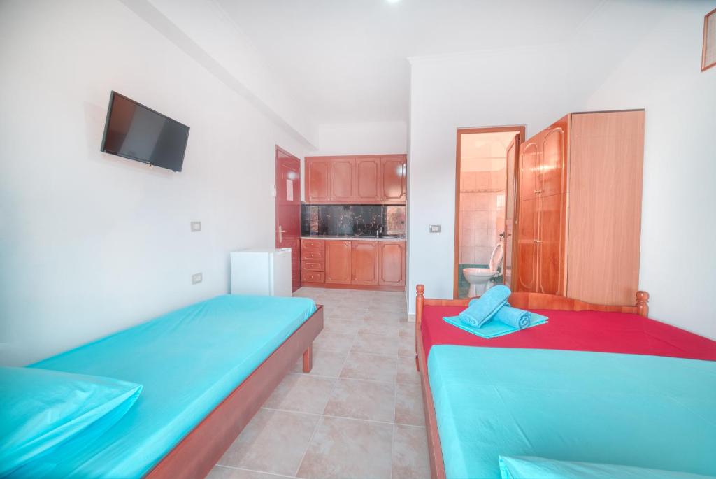 a room with two beds and a tv in it at Mirror Beach Ksamil - Vila Zervo in Sarandë