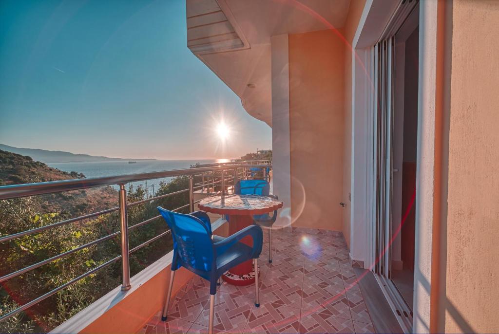 a balcony with a table and chairs and a view of the ocean at Mirror Beach Ksamil - Vila Zervo in Sarandë