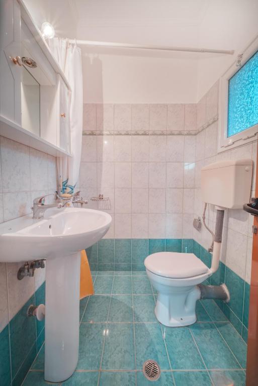 a bathroom with a sink and a toilet at Mirror Beach Ksamil - Vila Zervo in Sarandë