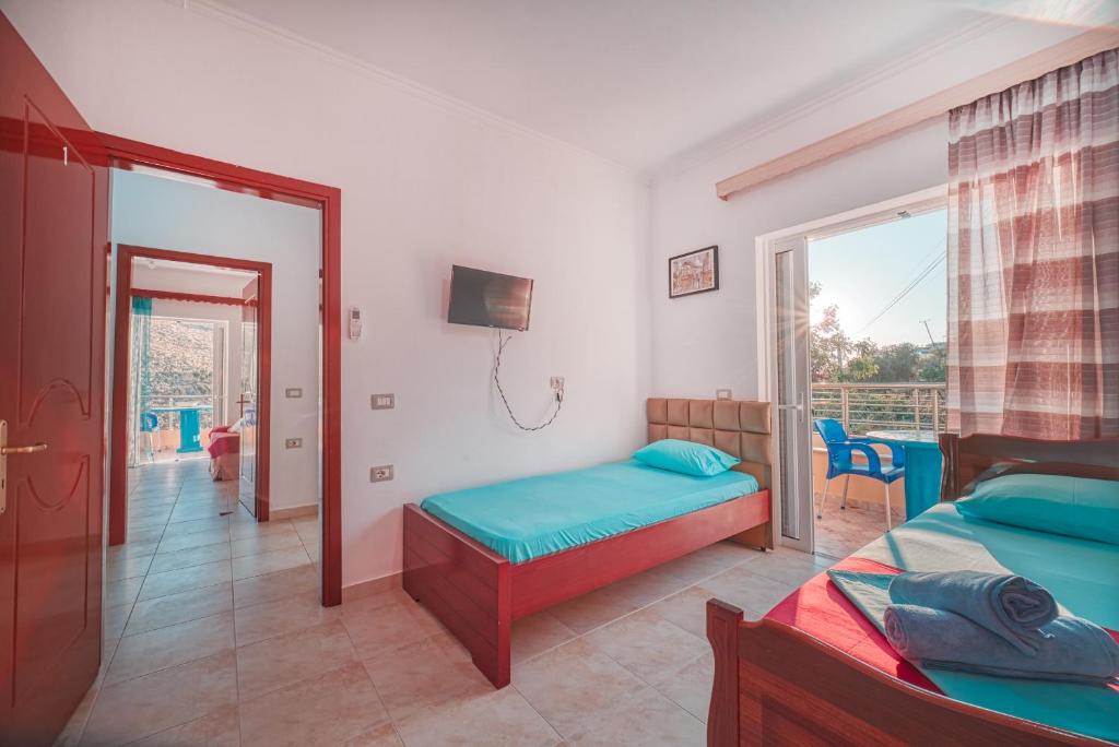 a bedroom with two beds and a balcony at Mirror Beach Ksamil - Vila Zervo in Sarandë